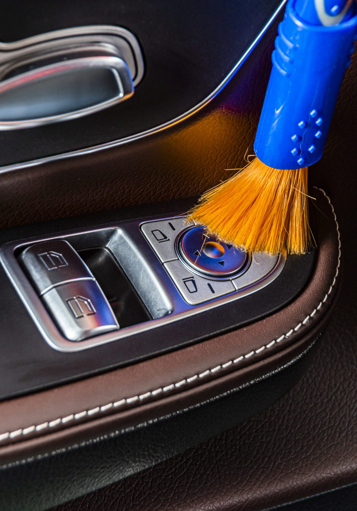 A man cleaning car interior panels and dashboard with a brush. Car detailing or valeting concept. Selective focus. Car detailing. Cleaning with sponge. Worker cleaning. Car wash concept solution to clean